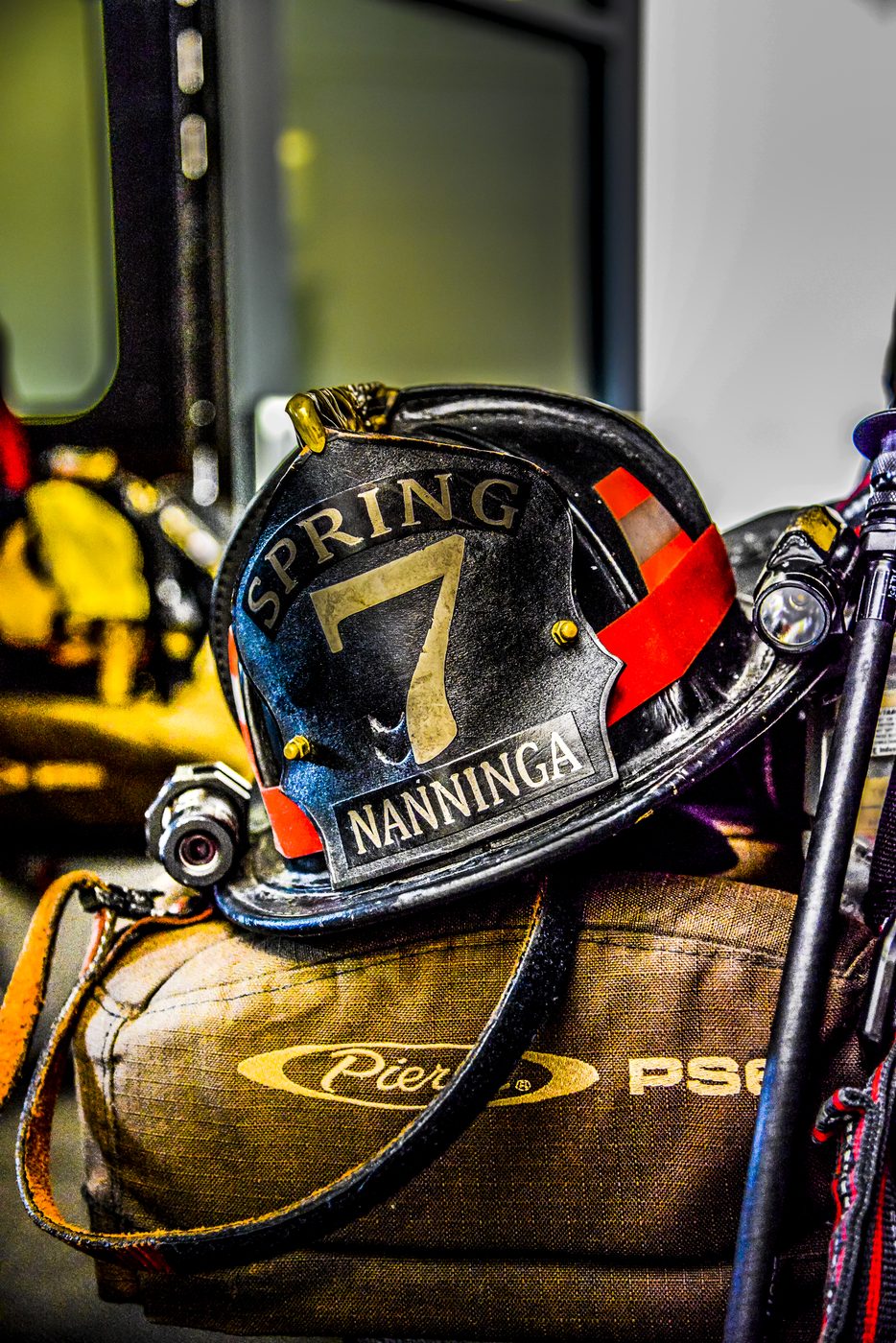 A close-up of a firefighter's helmet resting on turnout gear, shot by a real working photographer